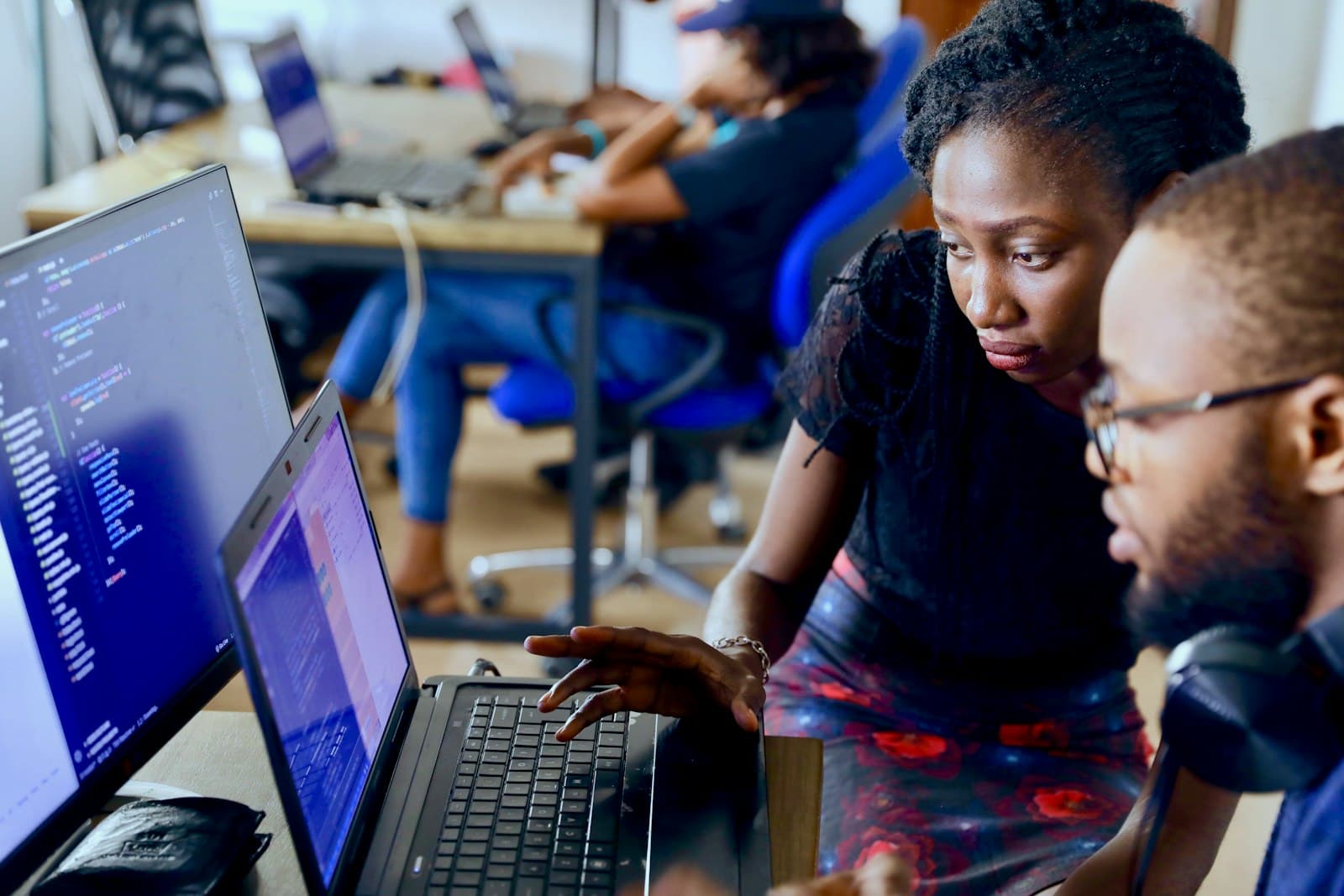 Two developers coding together on a laptop