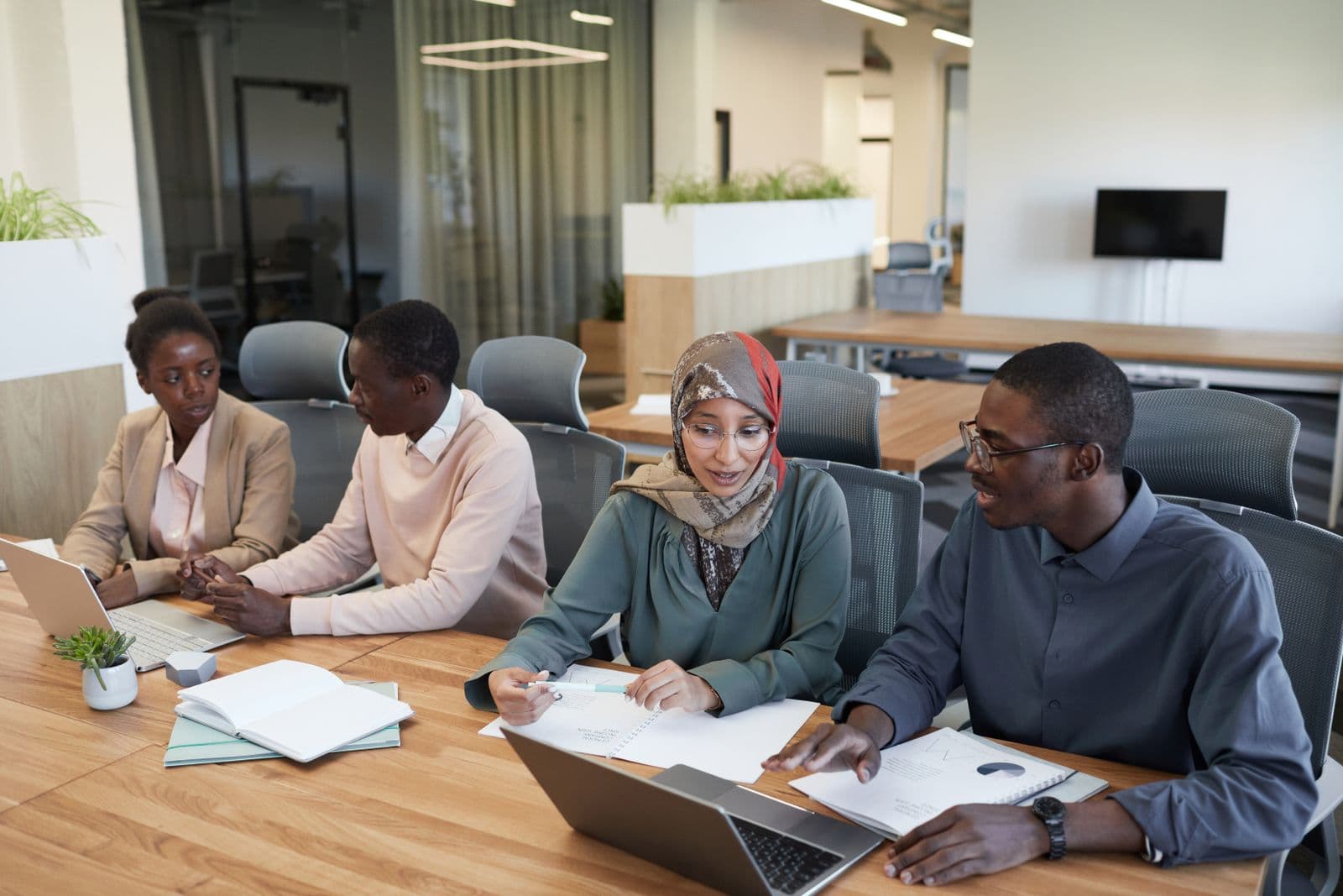 Work meeting around a table with laptops and documents
